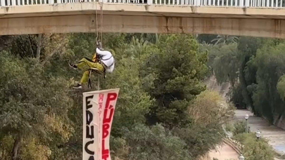 Impactante protesta educativa en Elche: Un profesor se cuelga de un puente para reivindicar la educación pública